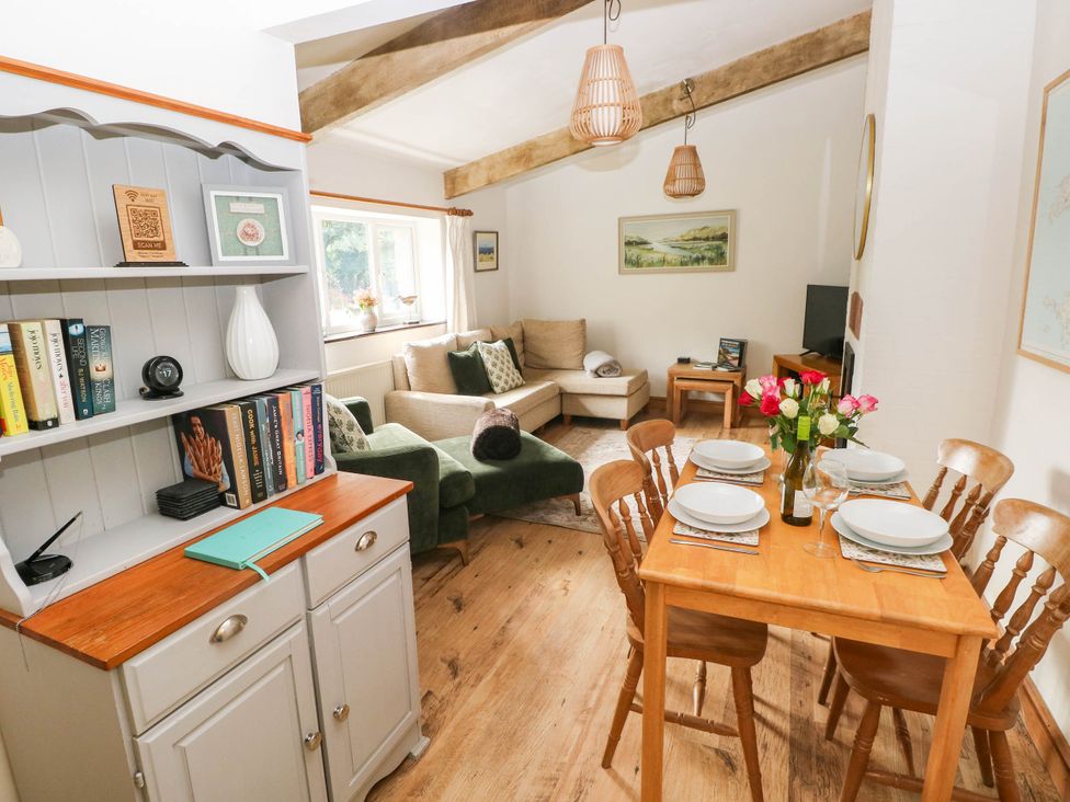 A living room with sofa and dining table at The Old Dairy near Solva