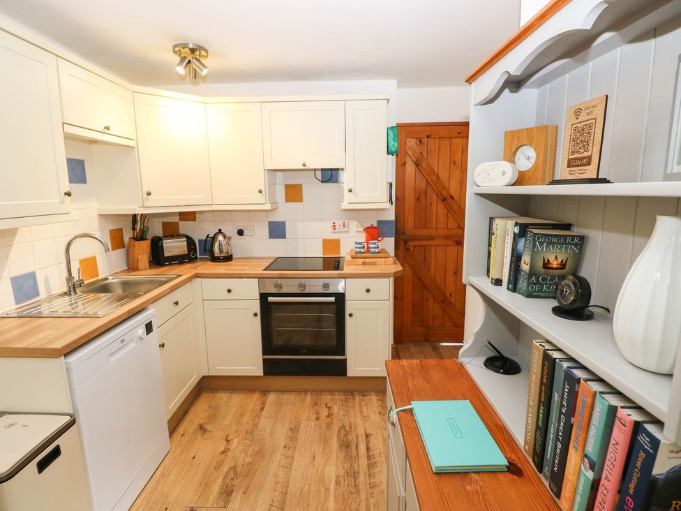 A kitchen with appliances and bookshelf at The Old Dairy near Solva