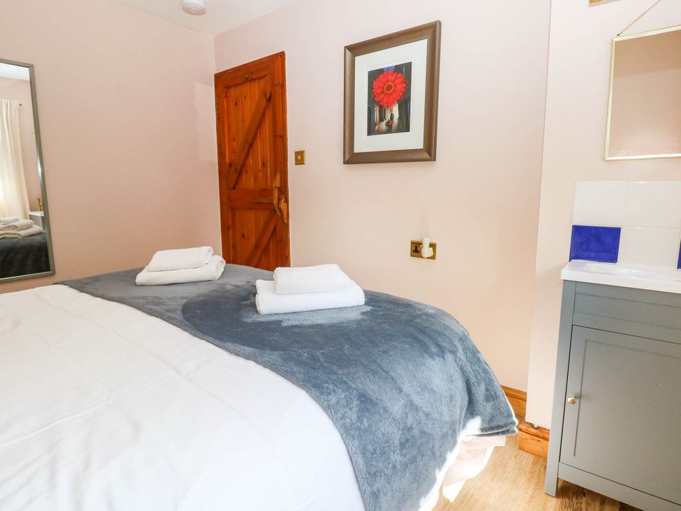 A bedroom with a bed and towels on it at The Old Dairy near Solva