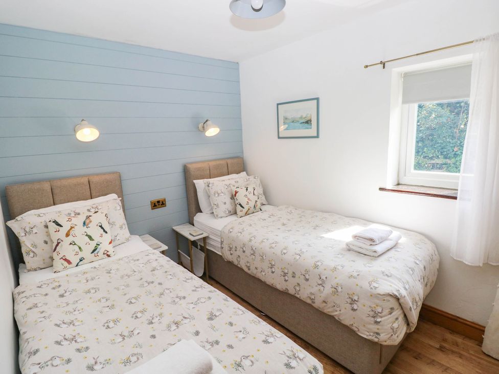 A bedroom with two beds and a window at The Old Dairy near Solva