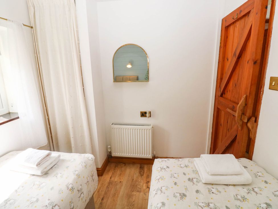 A bedroom with two beds and a radiator at The Old Dairy near Solva