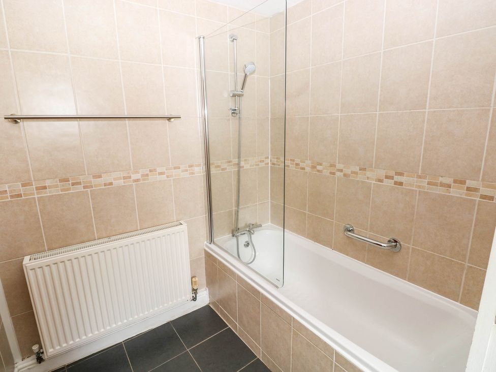 A bathroom with a bath and shower unit at The Old Dairy near Solva