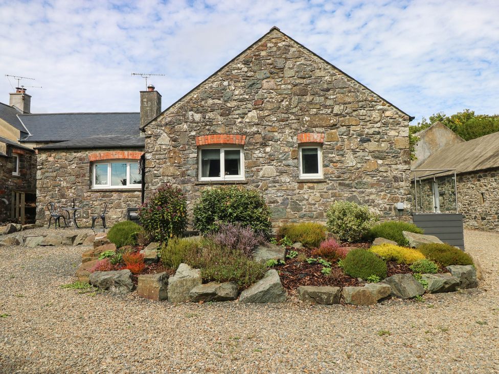 A stone house with garden and seating area at The Old Dairy near Solva