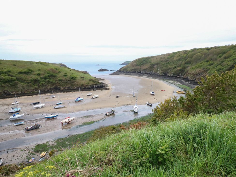 A view of boats on sand at a bay with hills at The Old Dairy near Solva