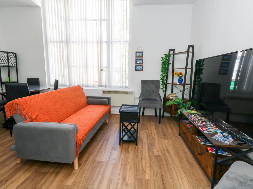 A living room with a sofa and television at Ocean Breeze in Weymouth