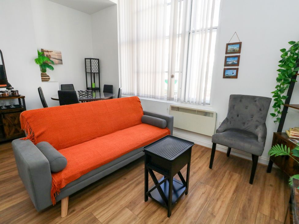 A living room with a sofa and armchair at Ocean Breeze in Weymouth