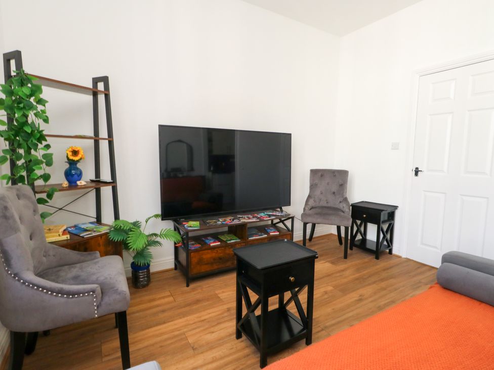 A living room with a television and seating area at Ocean Breeze in Weymouth