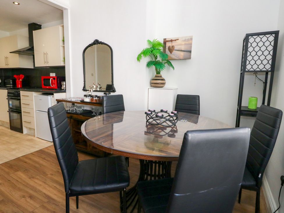 A dining room with a table and chairs at Ocean Breeze in Weymouth