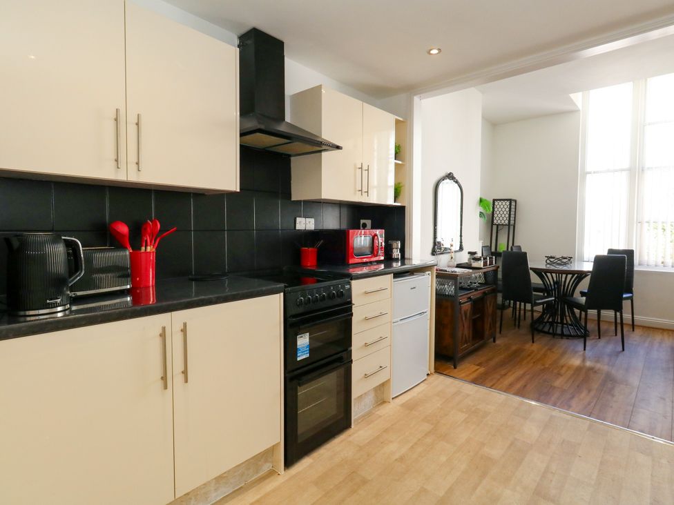 A kitchen with cabinetry and dining area at Ocean Breeze in Weymouth