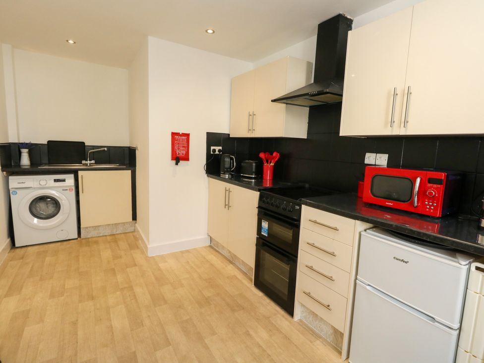 A kitchen with appliances and cabinets at Ocean Breeze in Weymouth