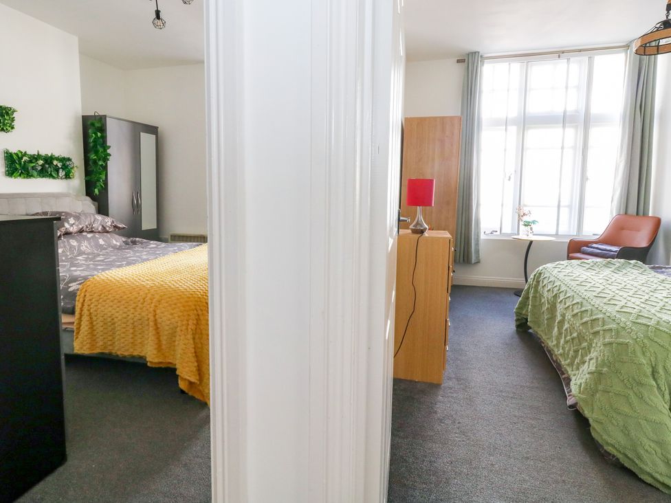 A bedroom with two beds and a dressing table at Ocean Breeze in Weymouth