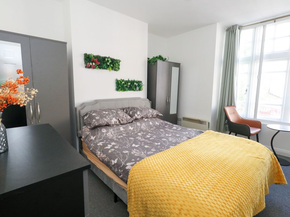 A bedroom with a bed and chair at Ocean Breeze in Weymouth