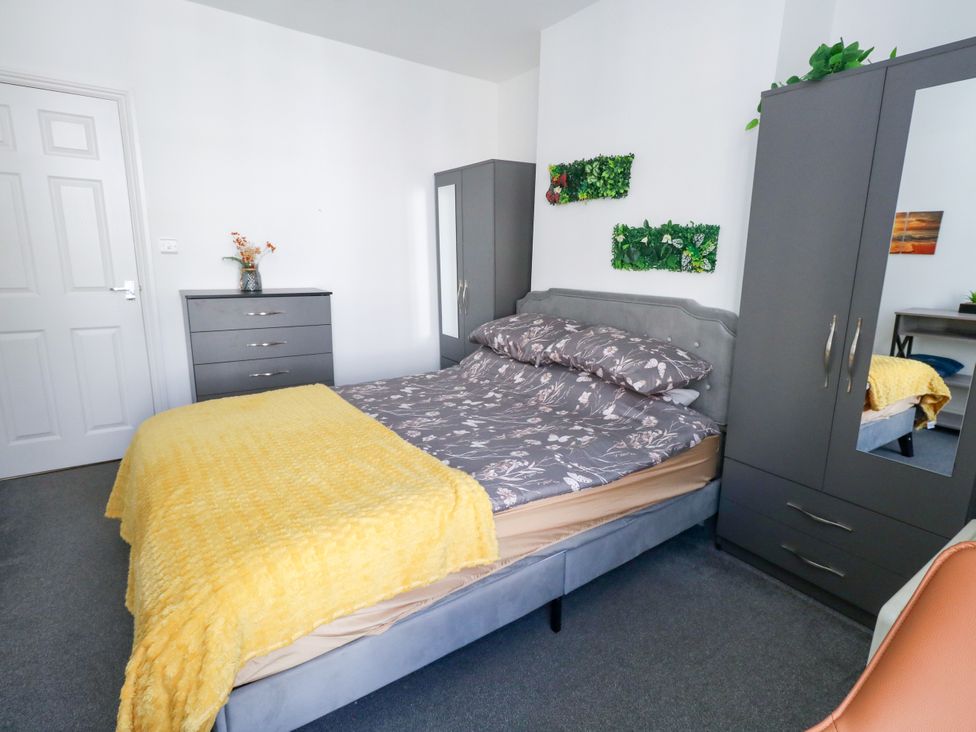 A bedroom with a bed and furniture at Ocean Breeze in Weymouth
