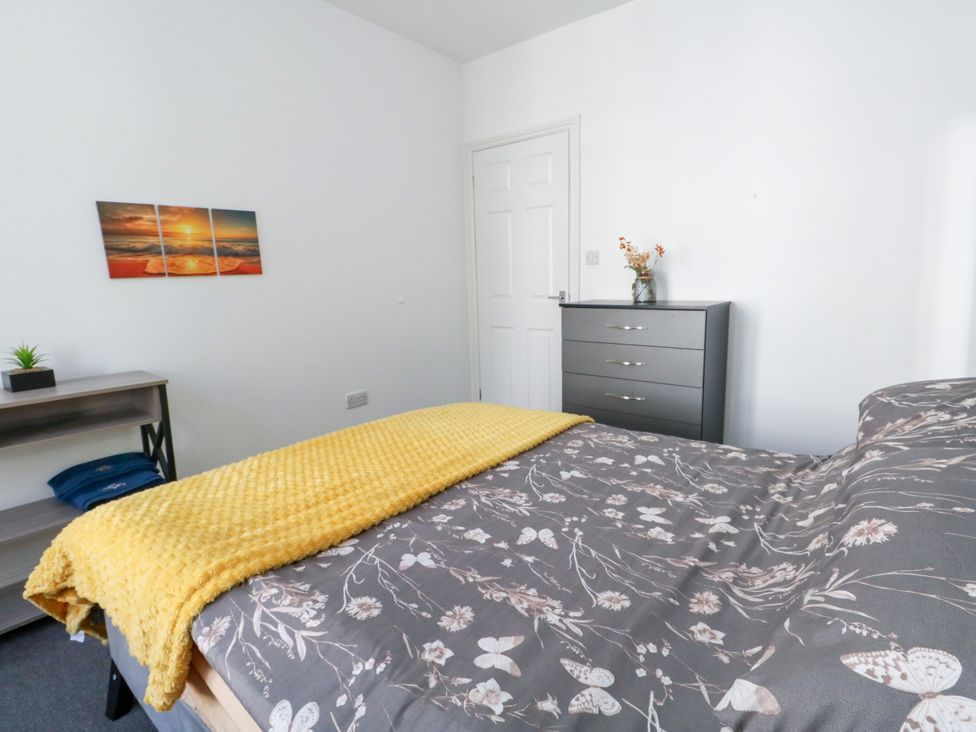 A bedroom with a bed and dresser at Ocean Breeze in Weymouth