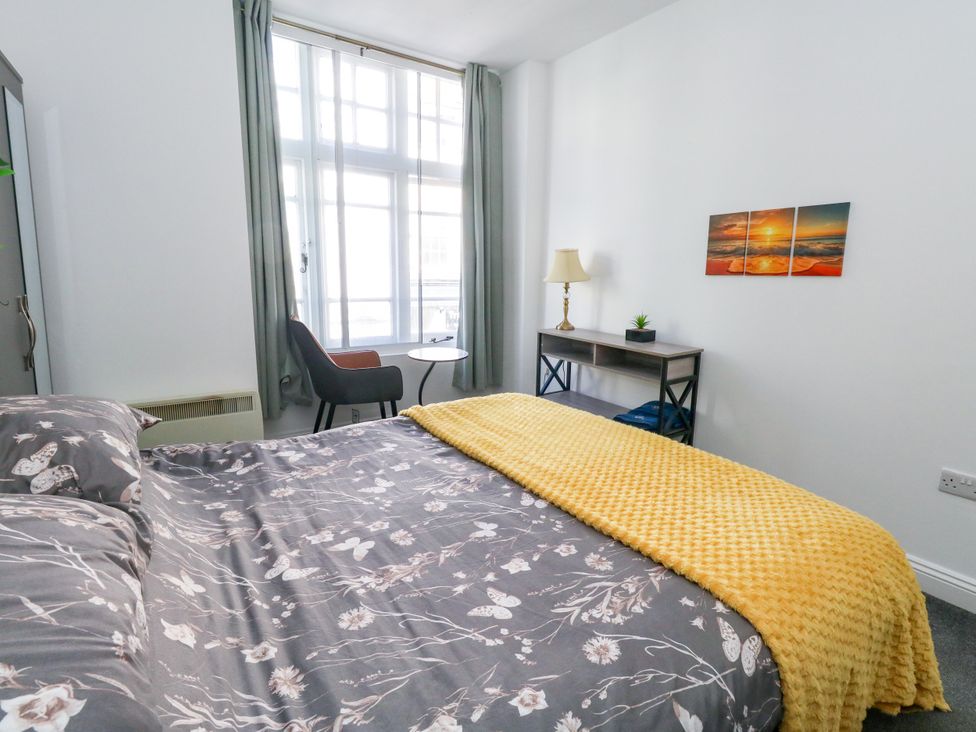 A bedroom with a bed and a table at Ocean Breeze in Weymouth