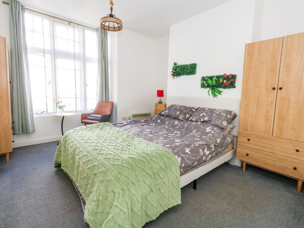 A bedroom with a bed and bedside table at Ocean Breeze in Weymouth