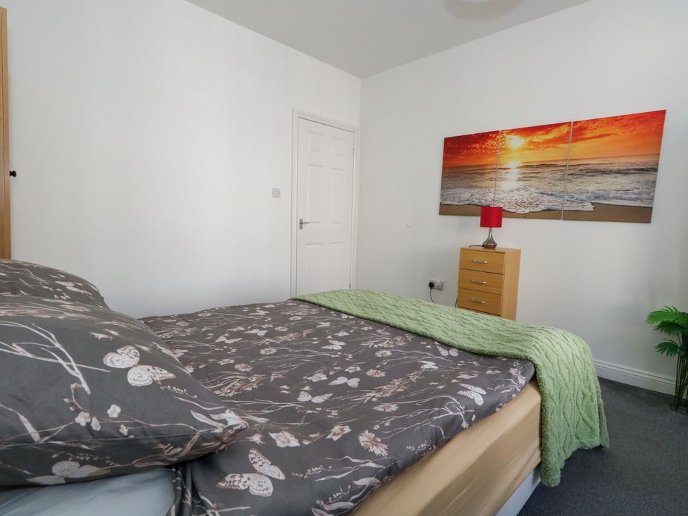 A bedroom with a bed and lamp at Ocean Breeze in Weymouth
