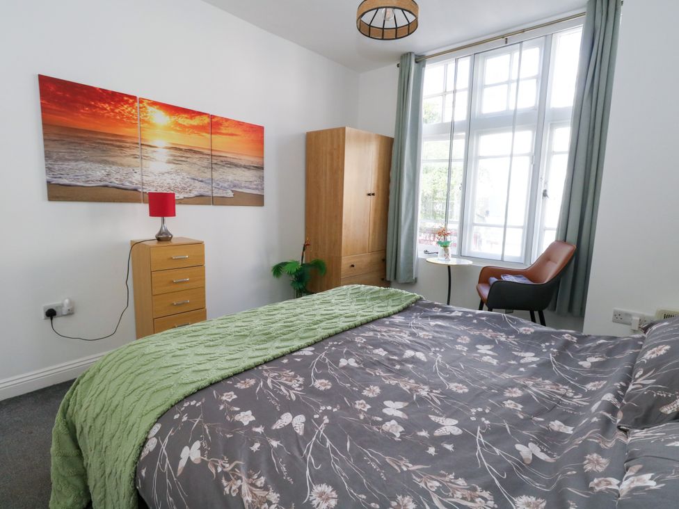 A bedroom with a bed and wardrobe at Ocean Breeze in Weymouth