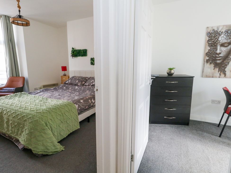 A bedroom with a bed and a dresser at Ocean Breeze in Weymouth