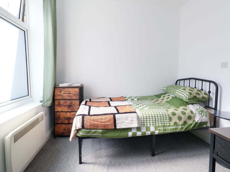 A bedroom with a bed and dresser at Ocean Breeze in Weymouth