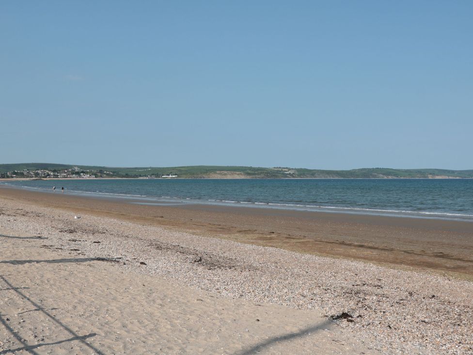 A beach with sand and water at Ocean Breeze in Weymouth