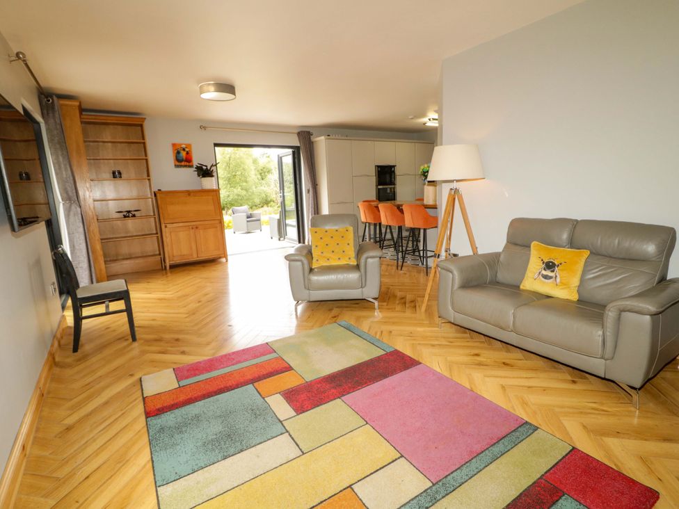 A living room with a sofa and an armchair at 3 bed property