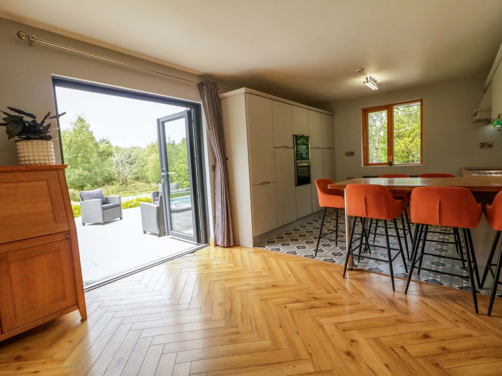 A kitchen with a dining table and sliding door at 3 bed property