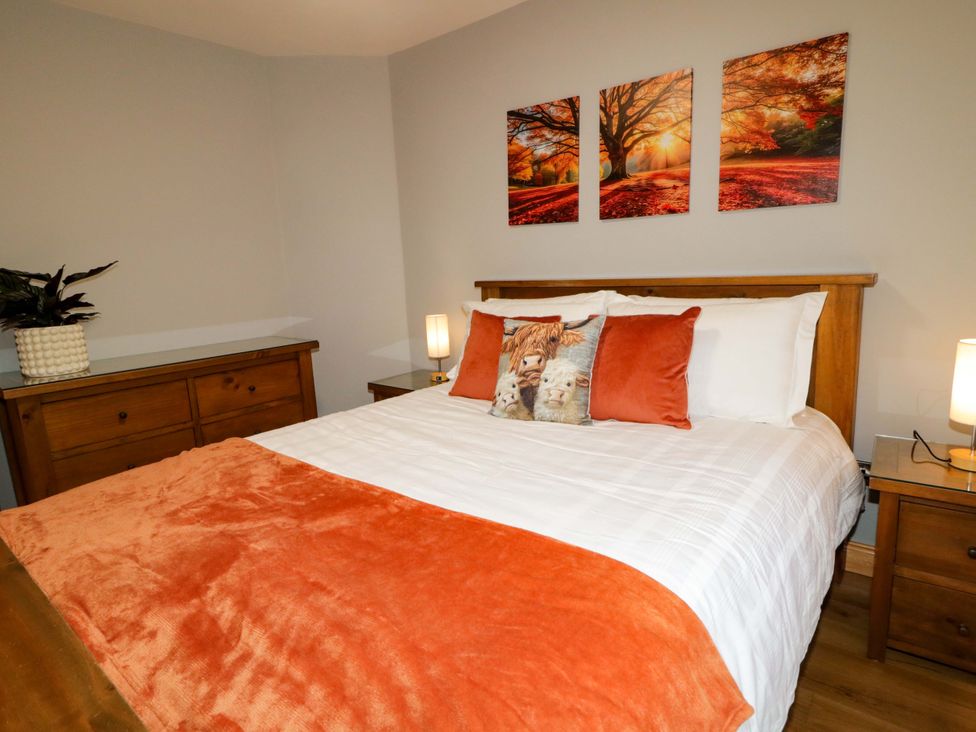 A bedroom with a bed and nightstands at 3 bed property