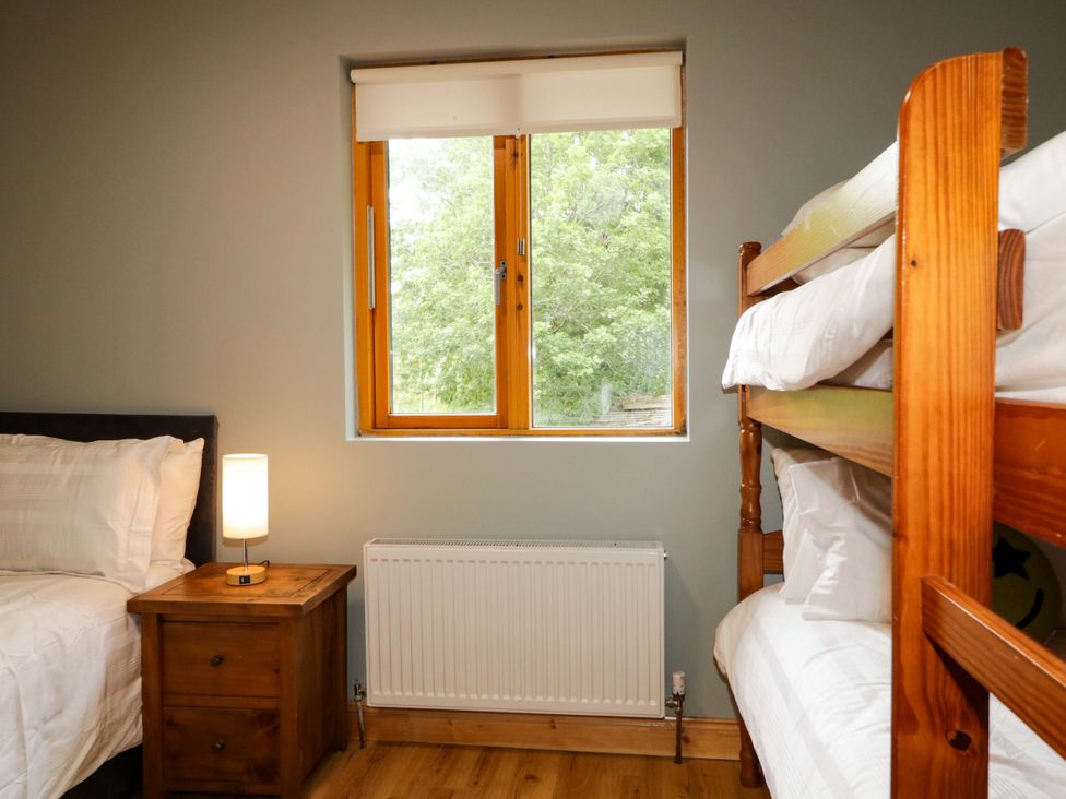 A bedroom with a bunk bed and a nightstand at a 3 bed property