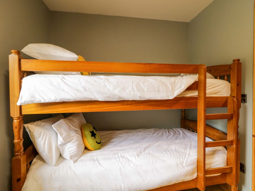 A bunk bed with pillows and a smiley face pillow in a bedroom