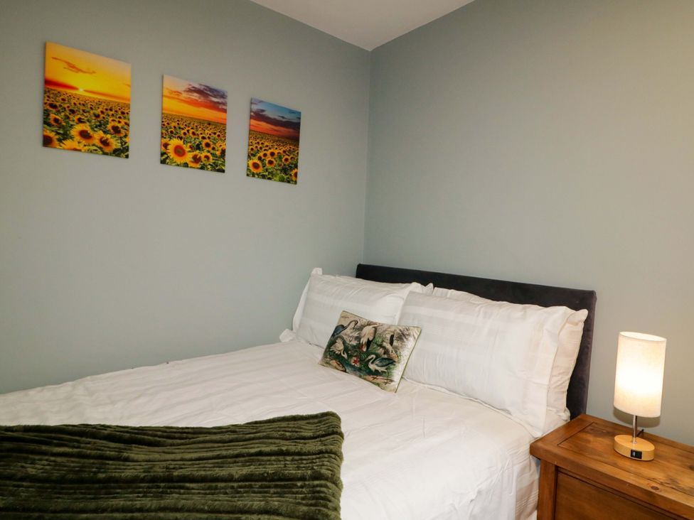 A bedroom with a bed and wall art at 3 bed property