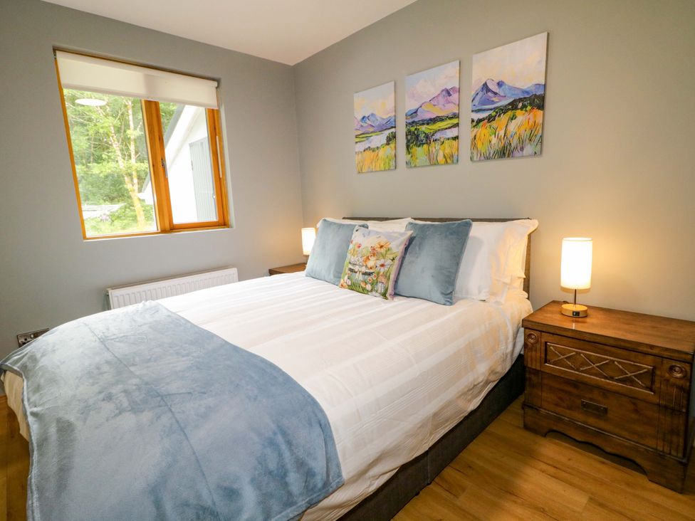 A bedroom with a bed and artwork on the wall at 3 bed property 