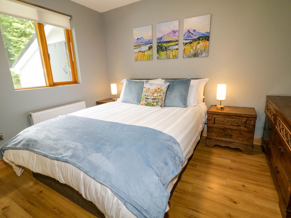 A bedroom with a bed and bedside tables at 3 bed property