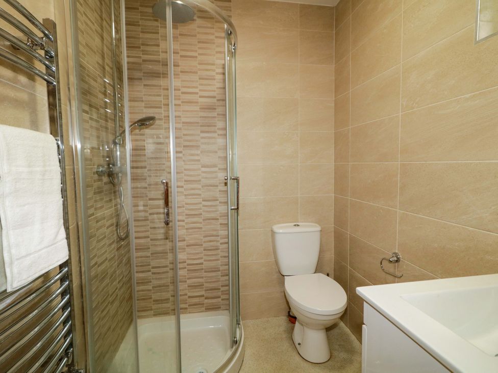 A bathroom featuring a shower, toilet, and sink in a 3 bed property