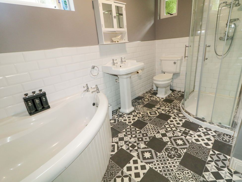 A bathroom with a bathtub, sink, shower, and toilet