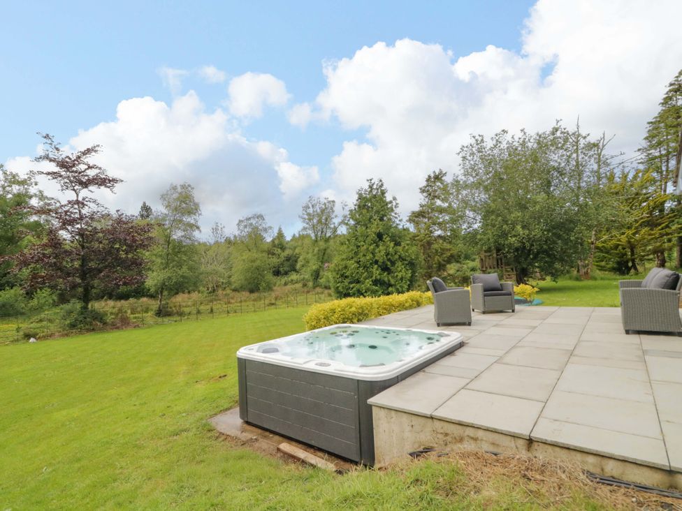 A garden with a hot tub and chairs at a 3 bed property
