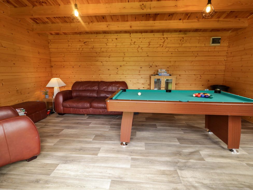 A snug with a pool table and seating area in a 3 bed property
