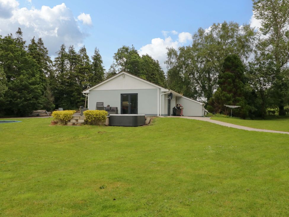 A house with a lawn and pathway in the garden area at 3 bed property 