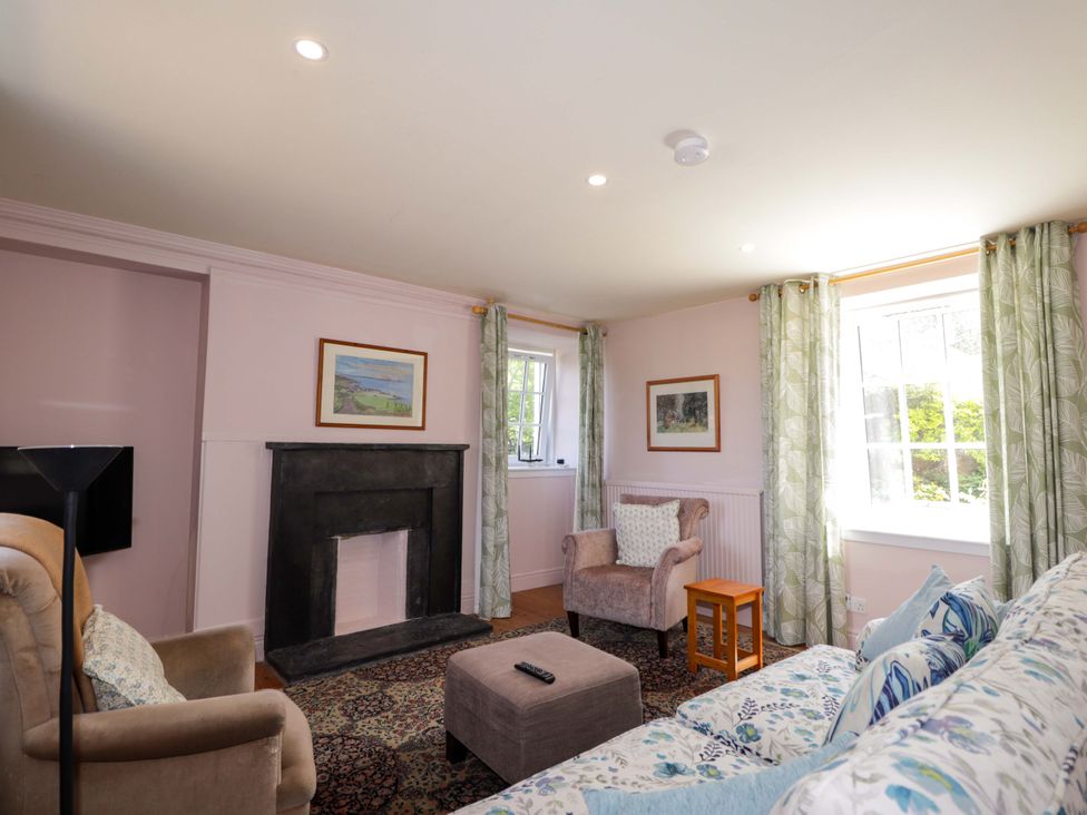 A living room with a sofa and armchair at 6 Hill Street