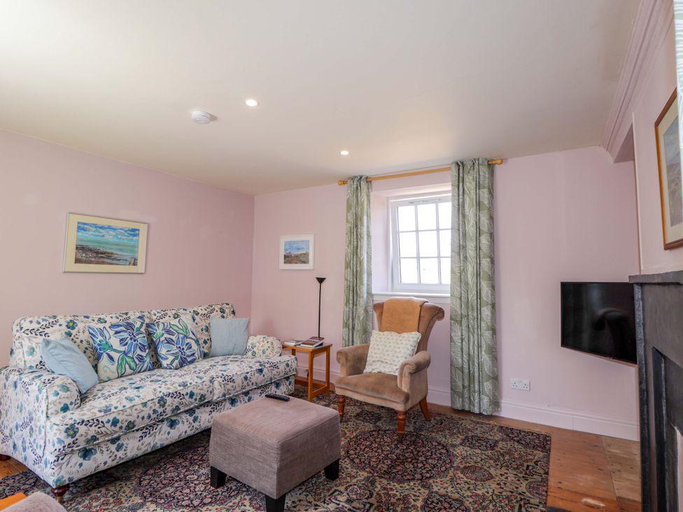 A living room with a floral patterned sofa and a beige armchair at 6 Hill Street