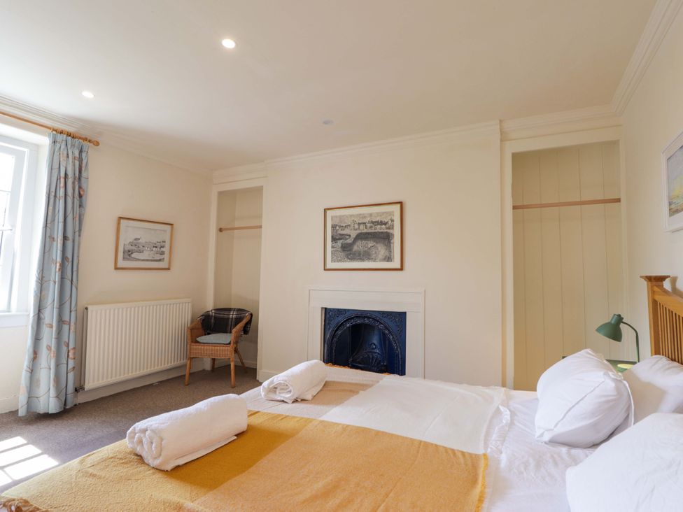 A bedroom with a bed and chair at 6 Hill Street 