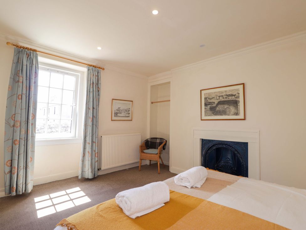A bedroom with a bed and a chair at 6 Hill Street 