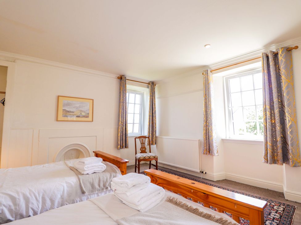 A bedroom with two beds and a chair at 6 Hill Street