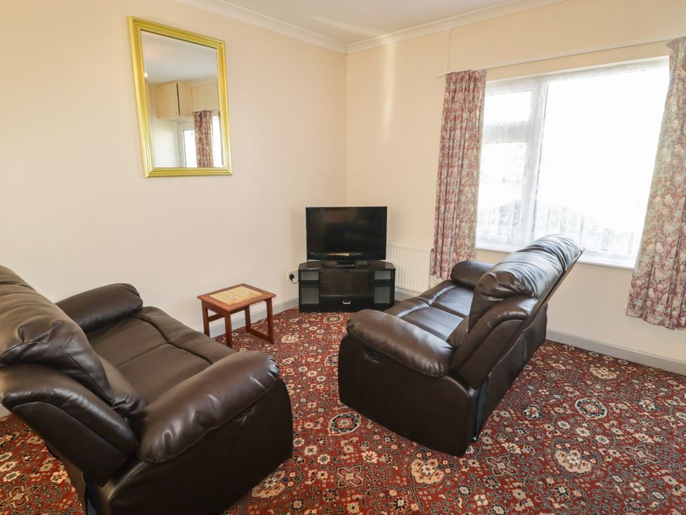 A living room with two sofas and a television at Cottage 1 in Tenby