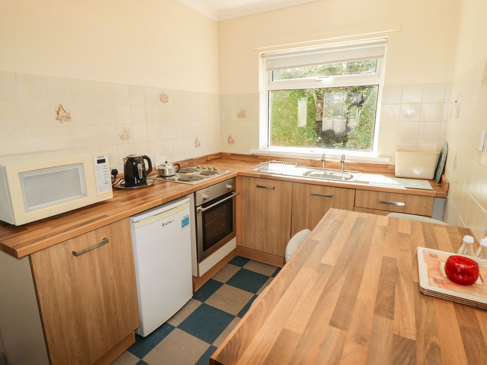 A kitchen with appliances and a sink at Cottage 1 in Tenby