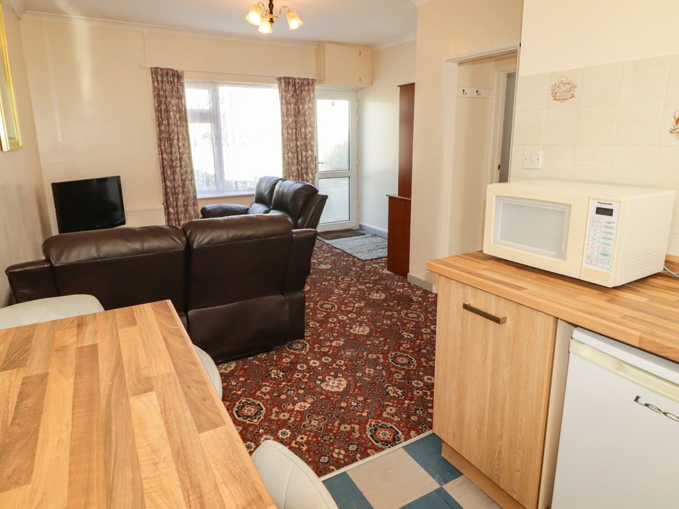 A living room with a sofa and television at Cottage 1 in Tenby