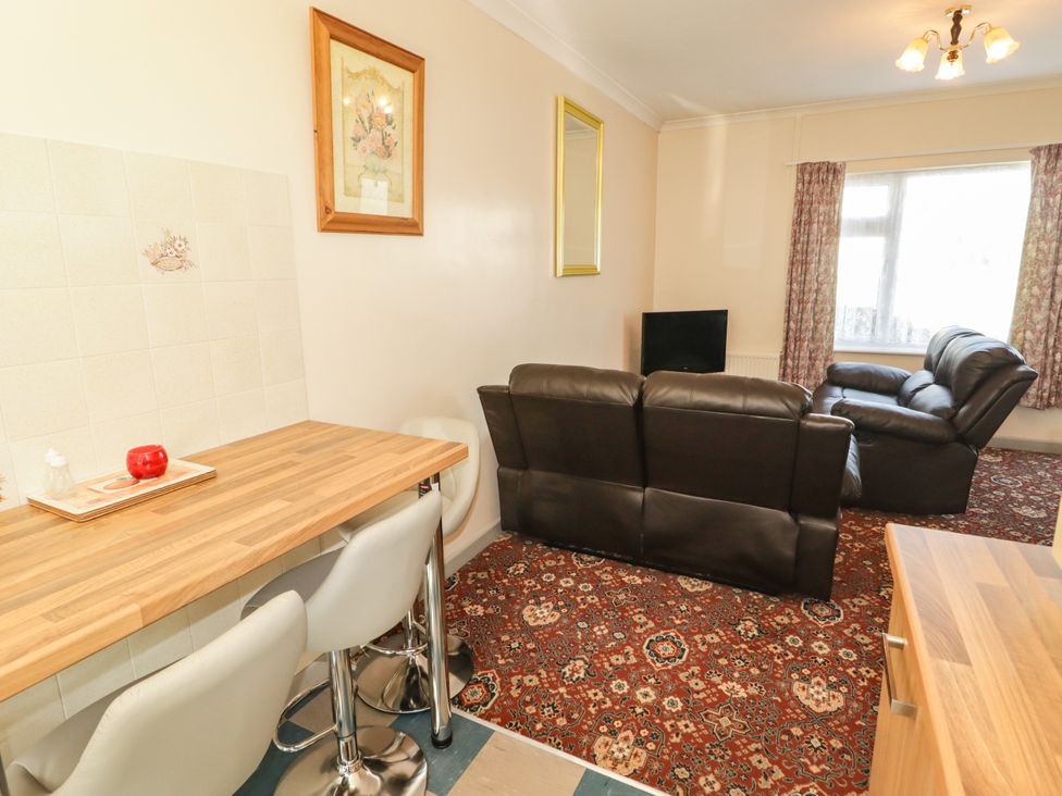 A living room with a sofa and table at Cottage 1 in Tenby
