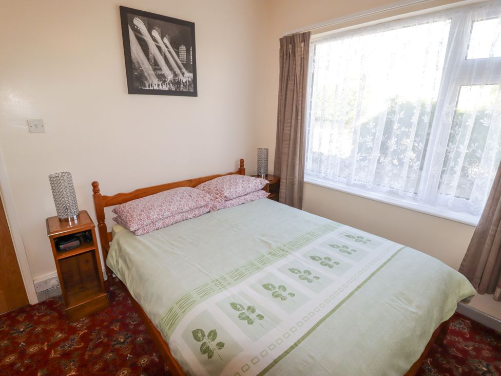 A bedroom with a bed and bedside table at Cottage 1 in Tenby