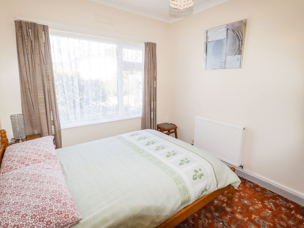 A bedroom with a bed and a window at Cottage 1 in Tenby