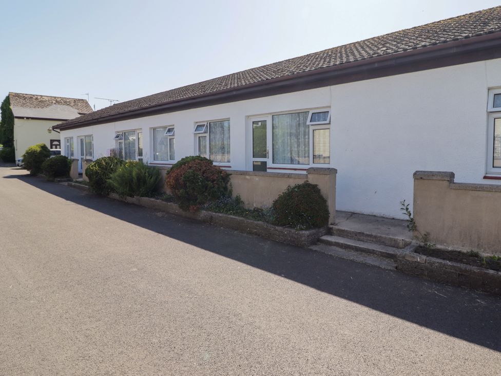A building with windows and landscaping at Cottage 1 in Tenby
